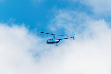 Small transport helicopter flying in the sky.
