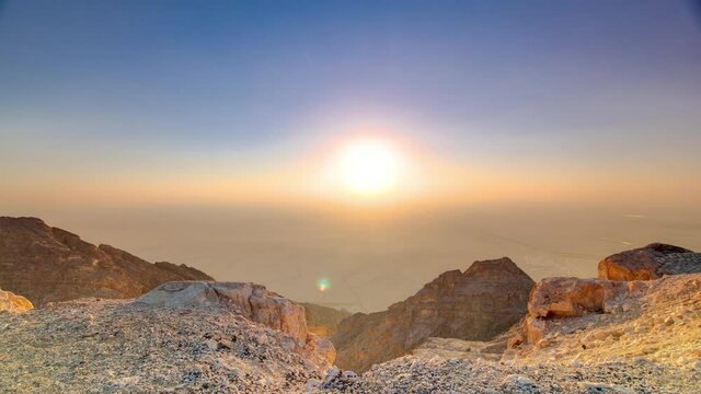 Sunset with rocks timelapse from Jebel Hafeet, mountain located primarily in the environs of Al Ain and offers an impressive view over the city. Aerial view from top