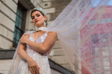 the bride in a ivory dress and veil, background red telephone cabin