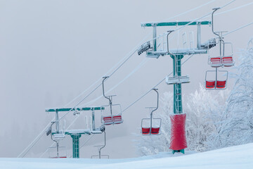 ski resort. The support of the lift is covered with snow and frost at dawn.