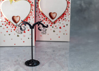 Mother's Day, Women's Day, Valentine's Day or Birthday. Earrings on a gray background. Gifts, sweets in the form of hearts.