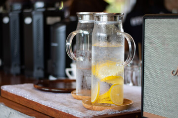Lemon in water in a clear glass jug with handle There were water droplets around the jug.