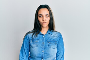 Obraz premium Young hispanic woman wearing casual denim jacket skeptic and nervous, frowning upset because of problem. negative person.