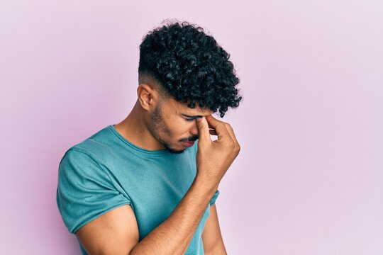 Young arab handsome man wearing casual clothes tired rubbing nose and eyes feeling fatigue and headache. stress and frustration concept.