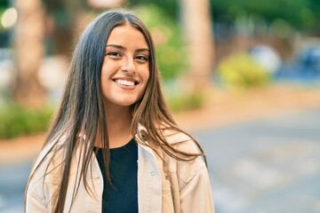 Fototapeta premium Young hispanic girl smiling happy standing at the city.