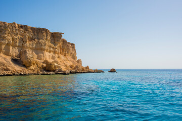 Fototapeta premium beautiful seascape with clear turquoise and blue water and bright yellow rocks off the coast of Sharm El Sheikh in egypt 