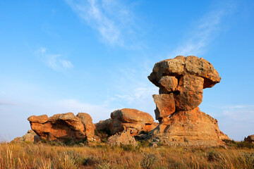 Sandstone rock formation against a blue sky and clouds, South Africa.