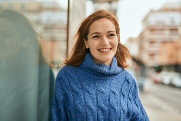 Young caucasian girl smiling happy standing at the city.