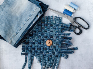 Old jeans ready to upcycling, thread, scissors and pattern, made from old jeans pieces. Concept of things reuse and natural resources preserving.