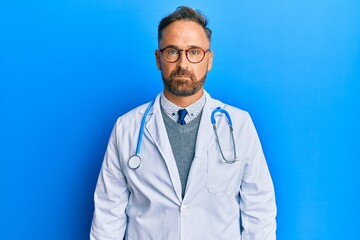 Handsome middle age man wearing doctor uniform and stethoscope depressed and worry for distress, crying angry and afraid. sad expression.