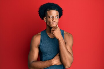 Fototapeta premium African american man with afro hair wearing sportswear serious face thinking about question with hand on chin, thoughtful about confusing idea