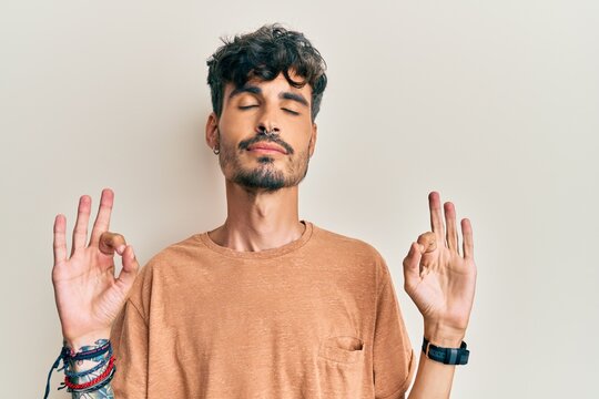 Young hispanic man wearing casual clothes relax and smiling with eyes closed doing meditation gesture with fingers. yoga concept.