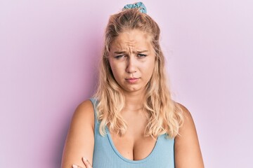 Young blonde girl wearing casual clothes skeptic and nervous, disapproving expression on face with crossed arms. negative person.