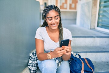Young african american student woman smiling happy using smartphone at the university campus