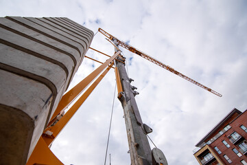 Bottom view of Tower crane against cloudy sky