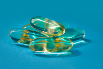 Omega 3 gel capsules. Fish oil pills. Healthy omega-3 on blue background.