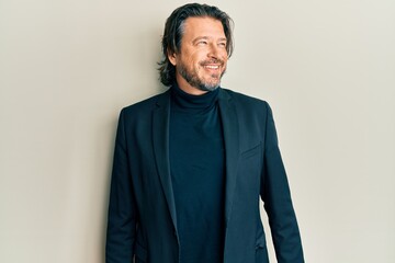 Middle age handsome man wearing business clothes looking to side, relax profile pose with natural face and confident smile.