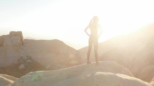 A woman looks out at a mountain vista.