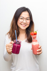 Beautiful healthy glasses women drinking strawberry and blueberry smotthie yogurt