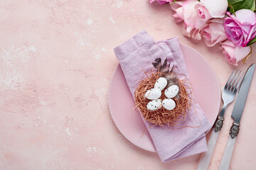 Easter spring greeting table setting with decorated with roses and nest with Easter eggs on blue color background. Top view. Space for text.