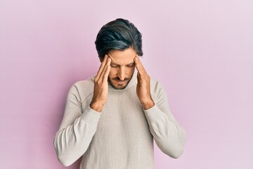 Young hispanic man wearing casual winter sweater with hand on head for pain in head because stress. suffering migraine.