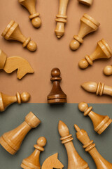 Black pawn surrounded by white chess pieces on flat background