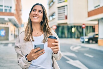 Young caucasian woman smiling happy using smartphone and drinking take away coffee at the city.