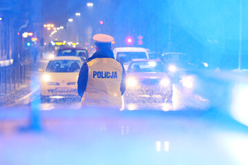 Policjanci ruchu drogowego kierują ruchem w czasie opadów śniegu.  - obrazy, fototapety, plakaty