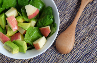 Simple salad contain spinach, apple and avocado with honey dressing.
