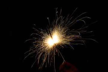New year sparkler in hands on black background