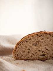 Homemade fresh wheat-rye bread on sourdough on a natural color linen napkin on a white background in the morning light
