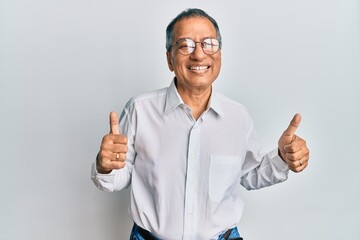 Middle age indian man wearing casual clothes and glasses success sign doing positive gesture with...