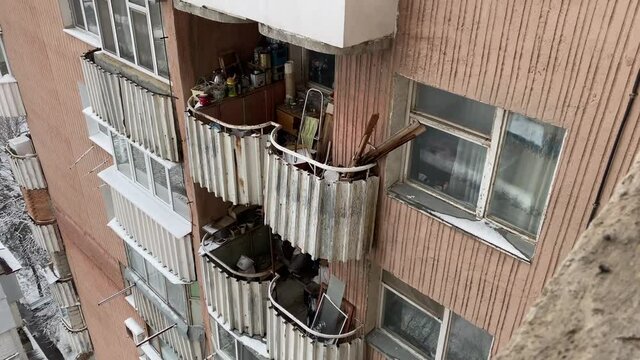 Open balcony with old stuff on a multi-story apartment building facade