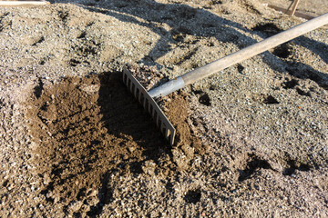 Rakes loosen the garden bed during the spring work on the personal plot