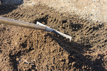 The rake loosens and levels the fertile soil
