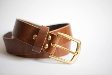 fastened fashionable men's brown leather belt with metal buckle isolated on white background