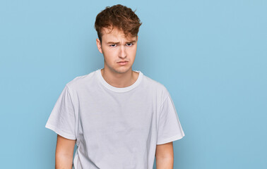 Fototapeta premium Young caucasian man wearing casual white t shirt skeptic and nervous, frowning upset because of problem. negative person.