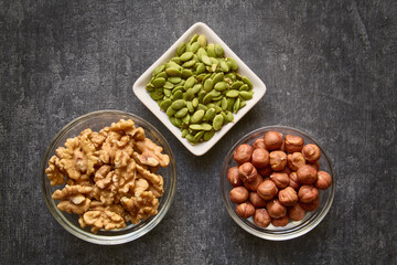 Nuts and pumpkin seeds close-up on gray background, healthy lifestyle
