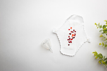 Different types of feminine hygiene products-menstrual cups, sanitary reusable pads on white background. Zero waste concept of menstruation.