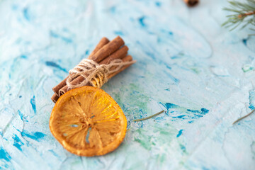 Cinnamon sticks on a light concrete background with dried oranges