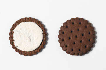 Two halves of chocolate-cream cookies on a white background.