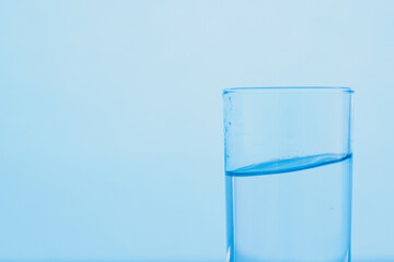 A glass of clear blue water. The concept of World Water Day.