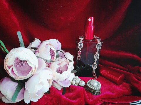 Valentine's Day gift: Vintage photo of jewelry and perfume on red velor in flowers
