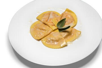 Pumpkin Ravioli with butter sauce and Sage leaves in white dish on white background