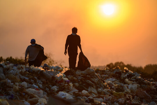 Poor people collect garbage for sale People living in garbage heaps walking to collect recyclable waste to be sold to poverty concept world environment day