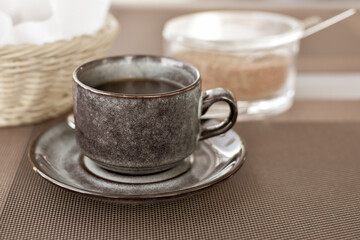 cup of black coffee in morning in cafe. Black coffee at business lunch against  backdrop of basket of toasted bread and cane sugar. Good morning energy, motivation concept. selective focus