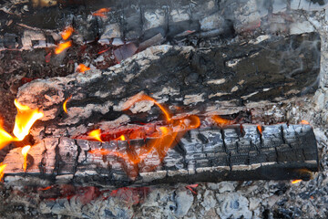 Glowing embers in hot red color, abstract background. The hot embers of burning wood log fire....