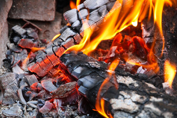 Glowing embers in hot red color, abstract background. The hot embers of burning wood log fire....