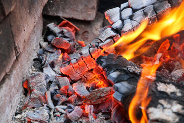 Glowing embers in hot red color, abstract background. The hot embers of burning wood log fire....