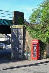 Red Telephone Kiosk beside Old Railway Bridge  